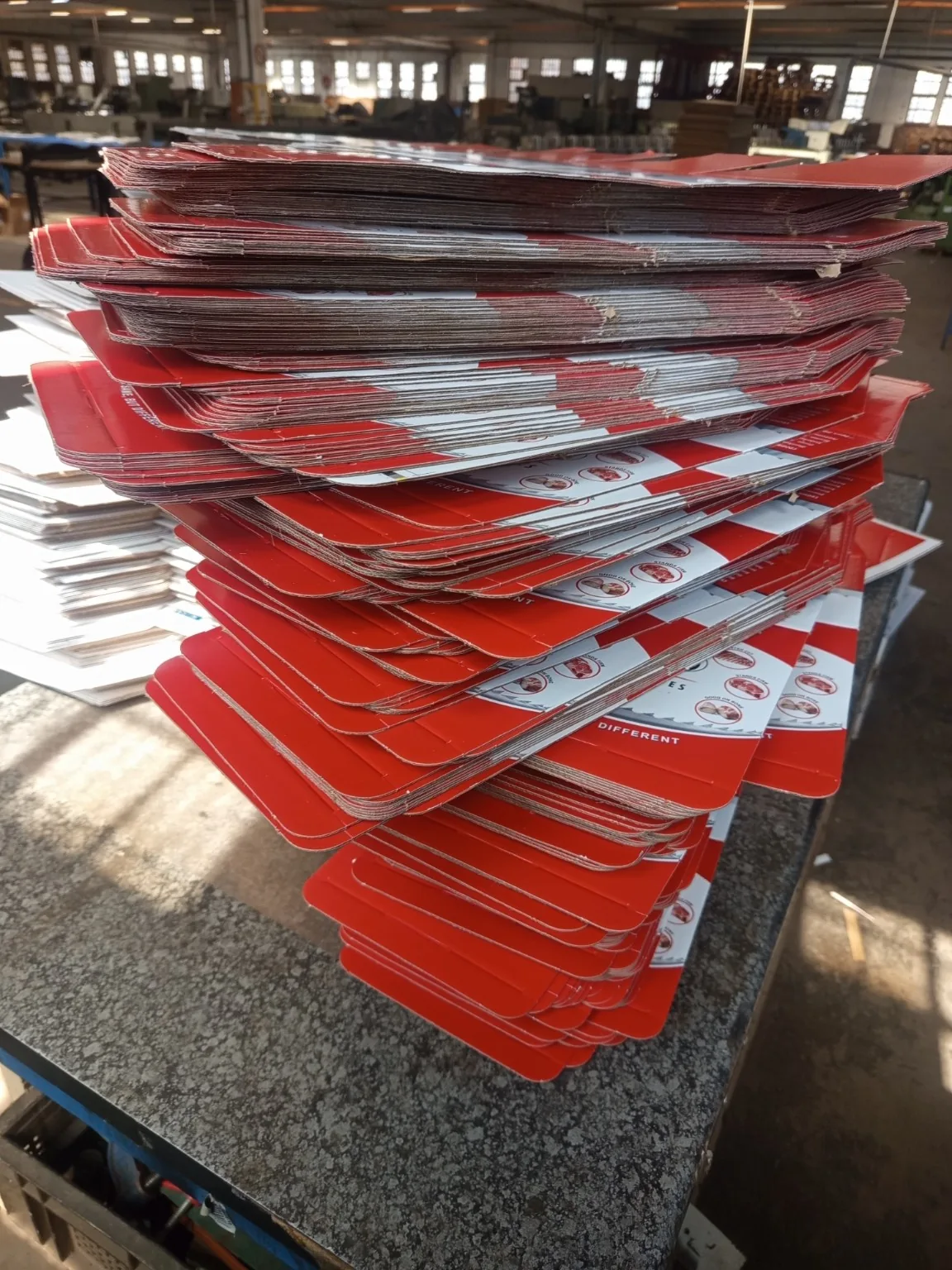 Custom Printed Corrugated Boxes for First Cut – OKTO Premium Bandsaw Blades Stacks of die cut printed box blanks during bulk packaging production