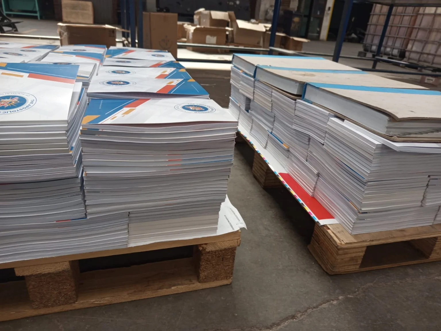 Stacks of finished branded notepads placed on pallets after bulk production