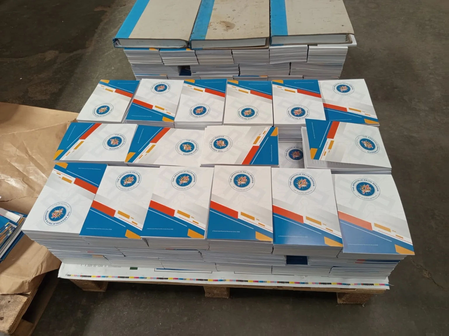 Wide view of finished branded notepads stacked on a pallet after production