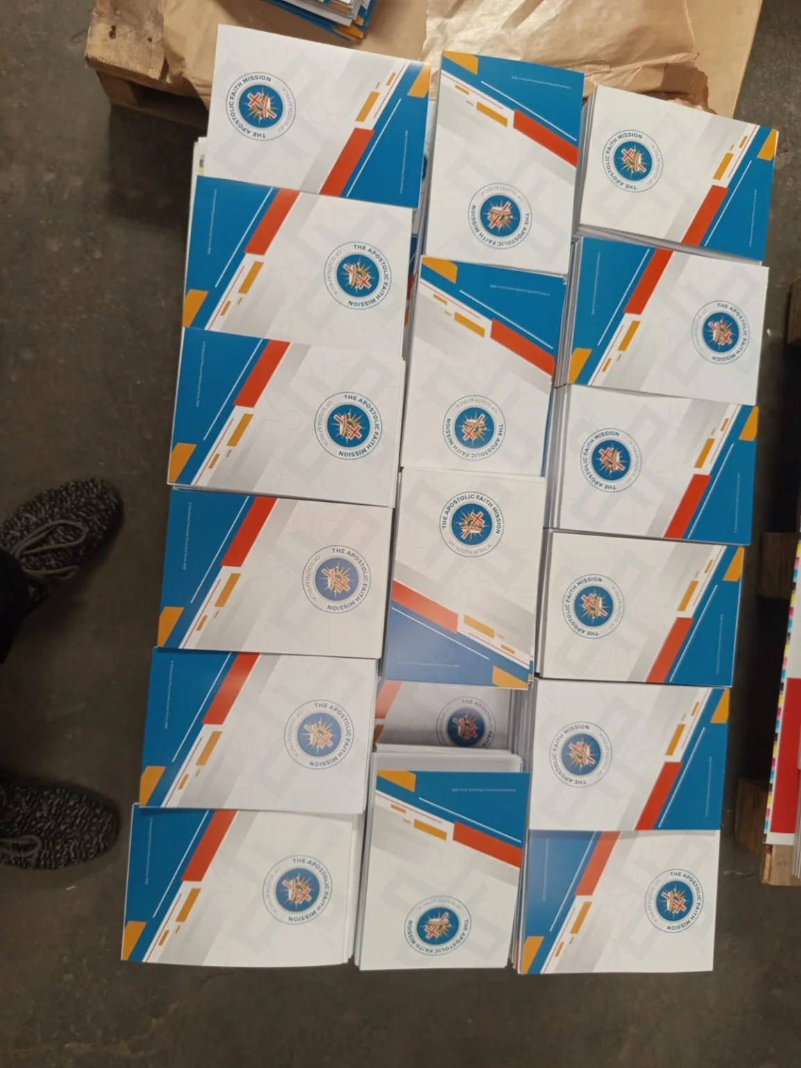 Overhead arrangement of finished branded notepads laid out during production inspection