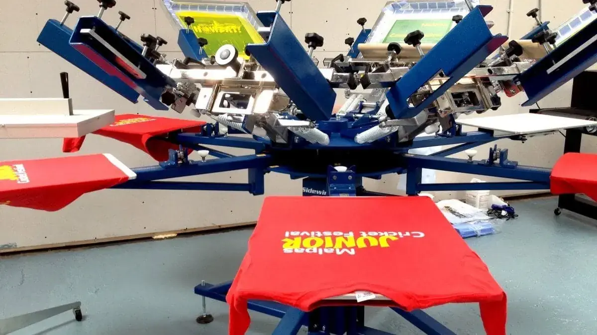 Multi-station screen printing carousel producing branded T-shirts in bulk