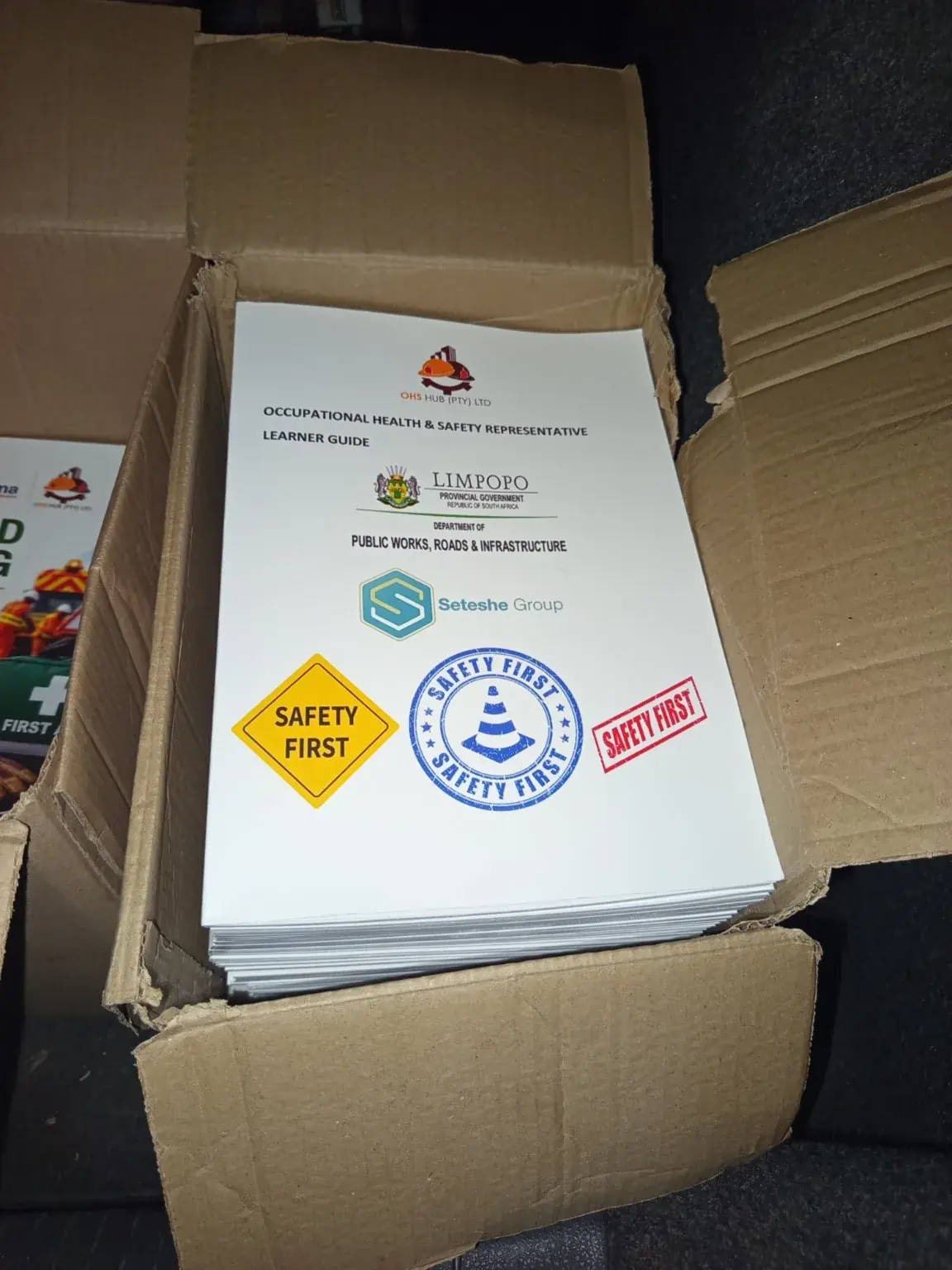 Occupational health and safety representative learner guides stacked in a carton