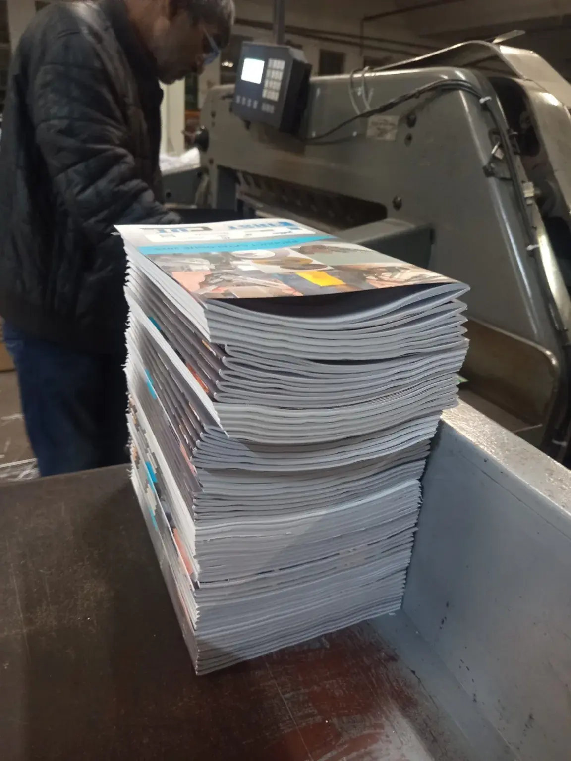 Printed training manuals stacked beside commercial finishing equipment