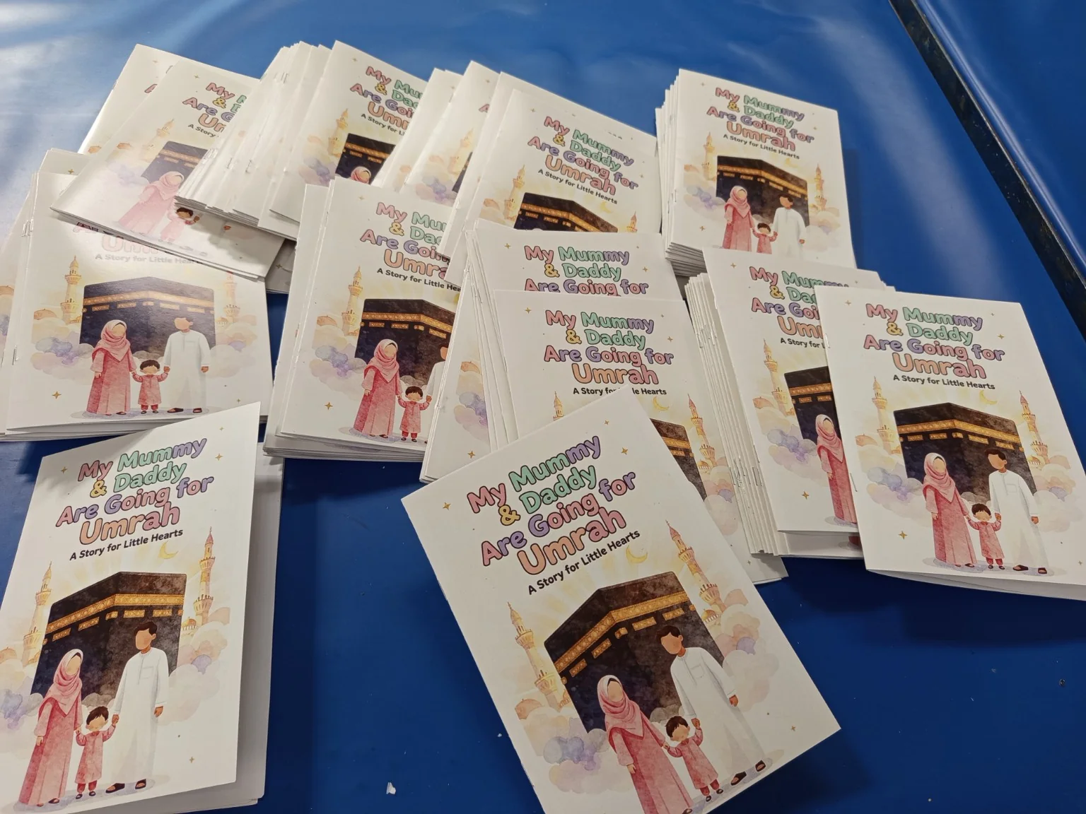 Bulk print run of finished My Mummy & Daddy Are Going for Umrah booklets stacked for packing