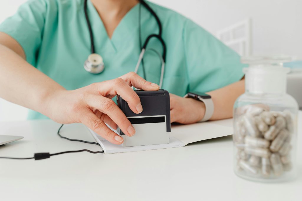 Rubber Stamp Maker Johannesburg: The Ultimate Guide to Custom Company Stamps Close-up of a doctor stamping a prescription with a bottle of pills on a desk.